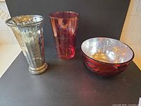 Group shot of silver mercury glass vase, cranberry etched vase, and cranberry bowl