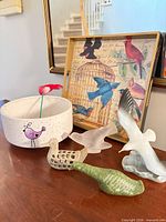 Group view of planter, tray, glass and stone bird figurines on tabletop
