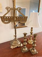 Group view of brass lyre stand, table lamp, pair candlesticks