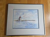 Full view framed watercolor print showing lighthouse scene, mat and silver frame