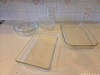 Group of all glass dishes and lids on countertop