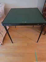 Full view of square green-top folding table