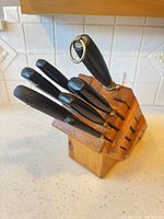 Side view of wood block holding six knives and honing steel