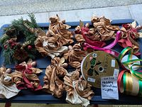 Ribbon spools, paper angel ornaments, evergreen wreath on table
