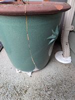 Side view showing green glaze, vertical crack, molded leaf accent