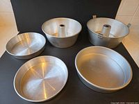 Five aluminum pans including two tube pans and three round cake pans