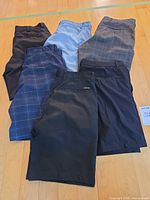 Six pairs of men’s shorts arranged on floor showing fronts