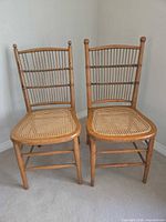 Pair of light brown oak spindle back side chairs with cane seats