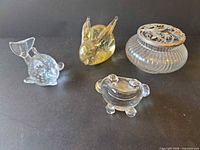 Group view of ribbed powder jar and three glass figurines