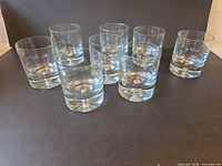 Seven of the eight clear glass tumblers arranged upright, showing overall form and clarity