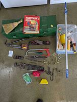 Overall lot overview showing toolbox, tools, hooks, book, broom, plastic tote, extension pole