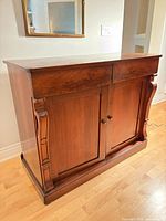 Front angled view showing drawers, doors, carved columns