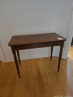 Full view of solid wood side table showing overall form and finish