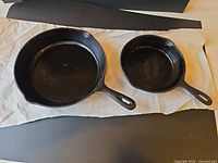 Top view of both cast iron skillets showing size difference and condition