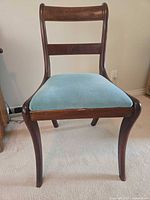 Front view of wooden accent chair with blue velvet seat
