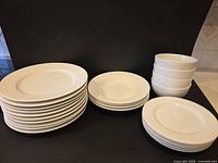 Stack of ten dinner plates, six side plates, four large bowls, four small bowls