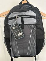 Front view of backpack showing tag, front pocket and mesh sides
