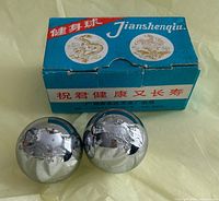 Pair of Baoding balls beside branded cardboard box