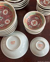 Stacks of larger and smaller longevity pattern dishes showing tops and 'MADE IN CHINA' base marks