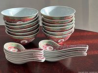 Two stacks of porcelain Longevity pattern bowls with matching spoons in front