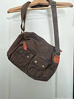 Front view of brown corduroy messenger bag on hanger