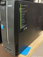 Front and left side of Acer Aspire XC-605 tower showing branding, front I/O ports, optical drive bay