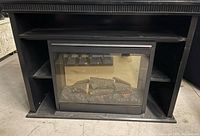 Front view of black TV stand with electric fireplace insert
