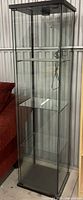 Full view of IKEA DETOLF cabinet showing glass panels, shelves, and black frame