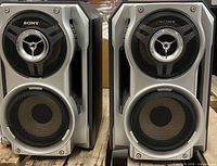 Front view of both SS-RV990 speakers showing dual woofer layout and tweeter