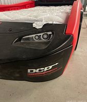 Front right corner showing headlight decal and chipped edge