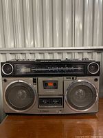 Front view of Sanyo M-9990 boombox showing speakers, cassette deck, VU meters and clock