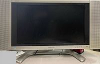 Front view of Sharp AQUOS LC-26DA5U TV with speakers and stand