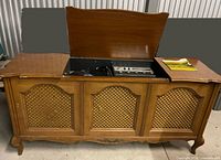 Front view of console cabinet with lids open showing turntable and control panel