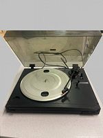 Turntable open showing platter, tonearm, dust cover