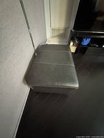 Top view of green leather ottoman with contrast stitching