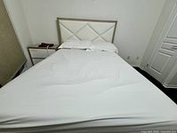 Full view of assembled queen bed showing mattress, frame, headboard and nightstand