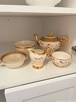 Group shot of all five porcelain pieces on shelf
