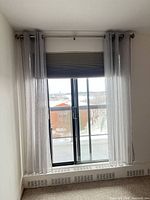 Full window view showing curtain panels, rod with finials, and cellular shade