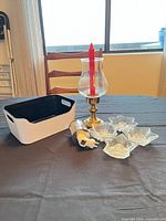 Group view showing brass hurricane holder with red taper, four glass star candle cups, white/black bin, nightlight warmer
