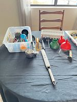 Overview of utensils on table including grater, whisks, funnels, dish rack and citrus squeezer