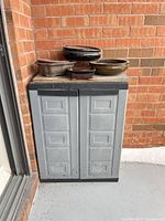 Cabinet closed with several pots stacked on top