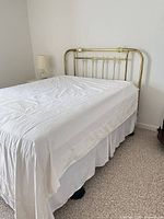 Queen brass headboard attached to bed showcasing size and rails