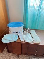 Revlon paraffin bath with cord, wax blocks, mitts, liners, manual on wooden cabinet