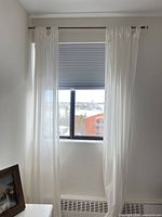 Curtain panels hung on metal rod in window