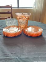 group of ten pink plates, pink vase-bowl and clear candy dish