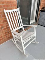 Front angle of white wooden rocking chair on balcony