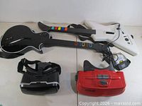Group shot of two Guitar Hero controllers, Shinecon VR headset and Nintendo Virtual Boy headset