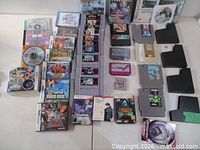 Wide shot showing SNES, N64, DS cases, discs, Genesis cartridge, memory card