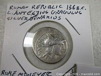 Obverse of denarius in holder showing helmeted head of Roma