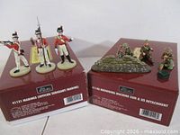 Both boxed sets with corresponding metal figures displayed on top